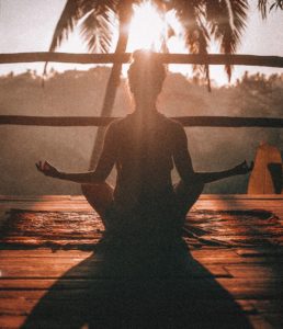 woman meditating in front sunset gratitude